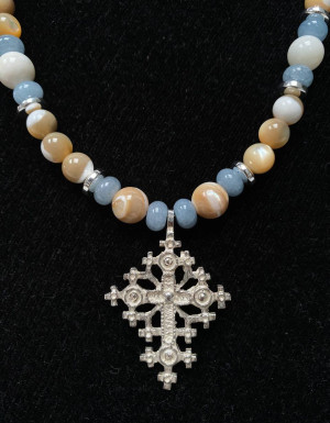 A blue-beige necklace with a silver cross