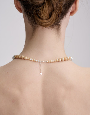 A blue-beige necklace with a silver cross